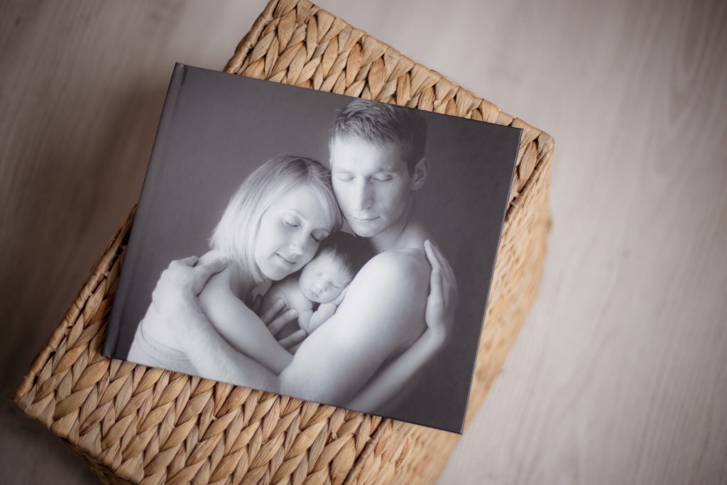 Fotogrāmata ar ģimenes fotogrāfiju no jaundzimušā fotosesijas