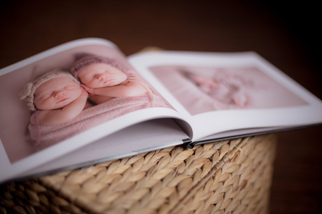 Atvērta fotogrāmata ar jaundzimušo fotogrāfijām